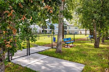 A park with a bench and a fence.